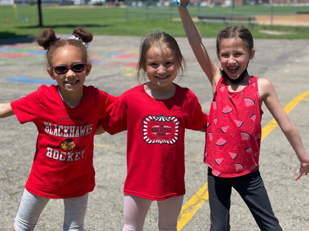 Three girls in red shirts on playground